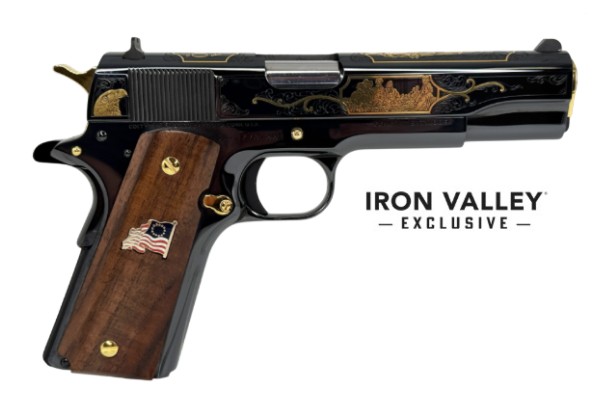 Colt 1911 Classic Government USA 250th, right profile, high-polished blued frame with gold engraving and dark walnut grips bearing a flag medallion.